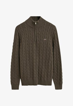 Maglione lavorato a maglia marrone scuro con colletto alto a coste e chiusura a metà zip. Presenta un motivo di lavorazione a trecce testurizzato in tutto il capo.