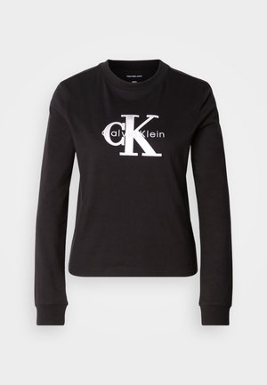 Černé dlouhé rukávy tričko z bavlny. Na přední straně se nachází bílé logo "Calvin Klein" a malý design "CK". Klasický střih s kulatým výstřihem.