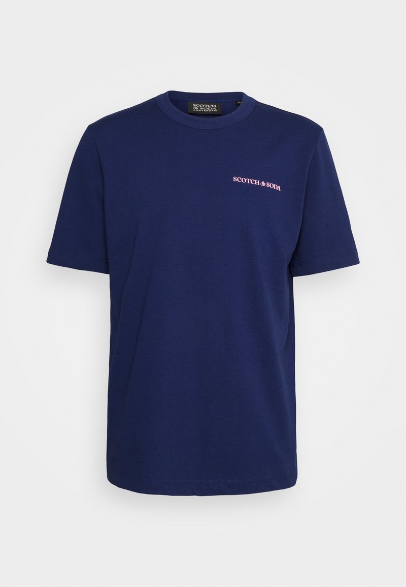 Námořnická modrá bavlněná trička s krátkými rukávy, kulatým výstřihem a malým růžovým logem "SCOTCH & SODA" na levém prsu. Hladká textura, běžný střih.