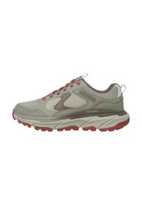 Zapatillas deportivas beige con parte superior de malla, acentos en rosa, suela texturizada y amortiguación prominente. Cuenta con logotipo y talón reforzado.
