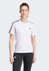 T-shirt blanc à manches courtes avec des accents noirs en trois rayures sur les épaules et un logo Adidas sur la poitrine gauche. Texture de tissu lisse.