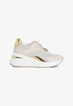 Sneakers caratterizzati da una combinazione di rete beige chiaro e pelle liscia, con dettagli dorati sul tallone e sul lato, e una suola spessa bianca.