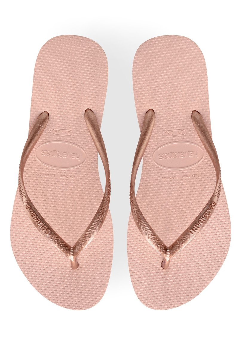 Lys rosa flip-flops med teksturert såle, med bronsefargede stropper og logo-detail, designet for komfort og uformell bruk.