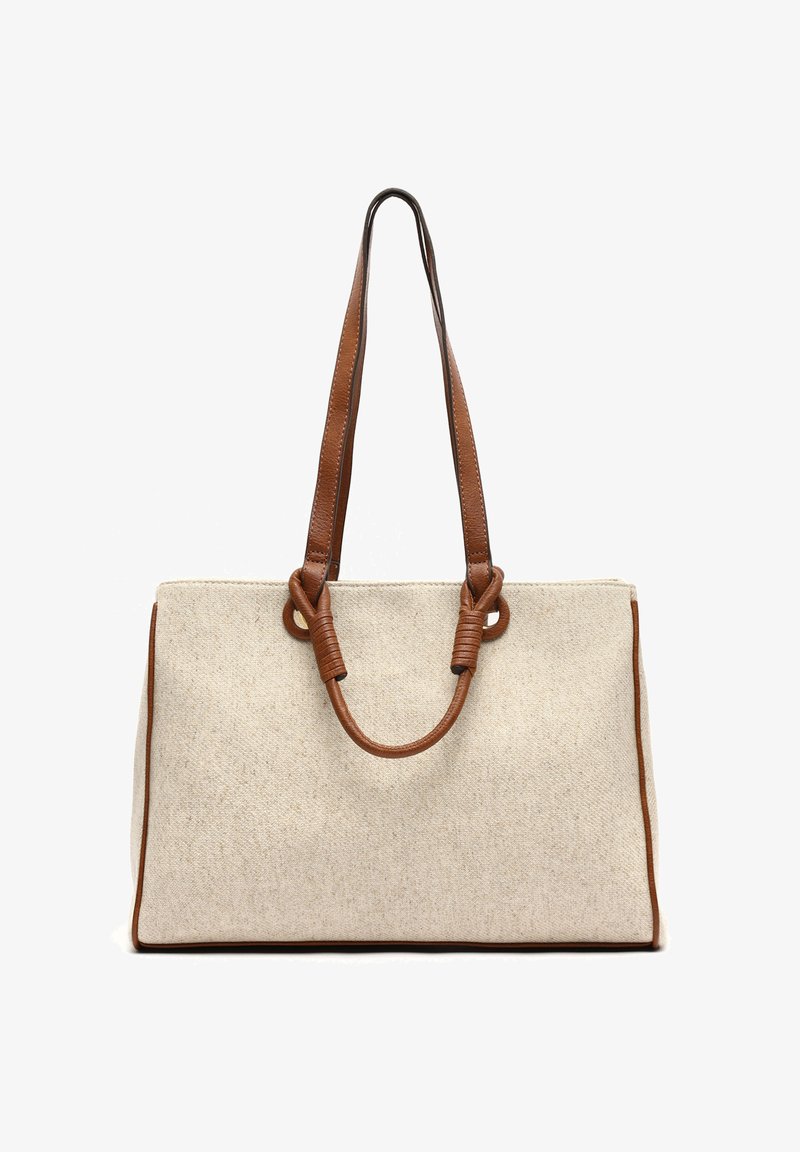 Beżowa torba na ramię z płótna z brązowymi skórzanymi uchwytami i detalami. Posiada wyraźny kształt i związane detale na uchwytach.