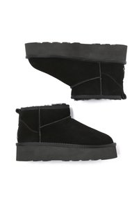 Schwarze Wildleder-Ankle Boots mit einer massiven schwarzen Gummisohle, ausgestattet mit einem weichen Innenfutter, runder Zehenform und minimalen Nähakzenten.