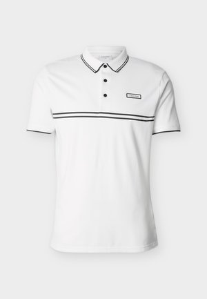 Biała koszulka polo z krótkim rękawem, czarnymi obramowaniami przy kołnierzu, krawędziach rękawów, guzikach oraz czarnym poziomym paskiem na wysokości klatki piersiowej z logo Calvin Klein.