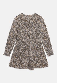 Långärmad, knälång klänning med blå och bruna blommönster på krämfärgad bakgrund, med en samlad midja och volangkantade ärmslut.