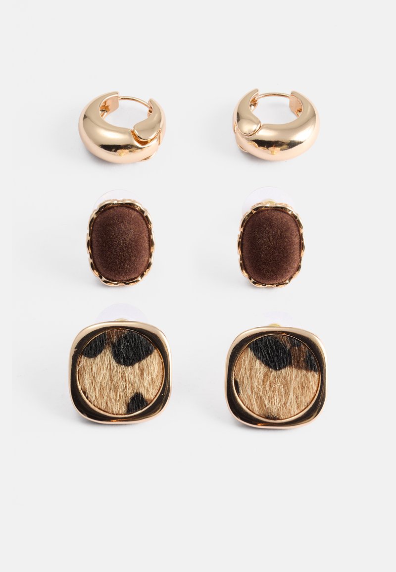 Auksinės spalvos auskarų rinkinys apima dvi žiedų formas ir dvi kaiščių dizainus. Vienas kaištis turi rudos medžiagos akcentą, o kitas turi leopardinį raštą.