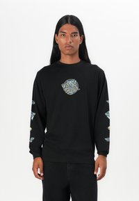 Zwart langemouwen T-shirt met een centrale afbeelding met "Santa Cruz" in kleurrijke tekst, en decoratieve patronen op beide mouwen.