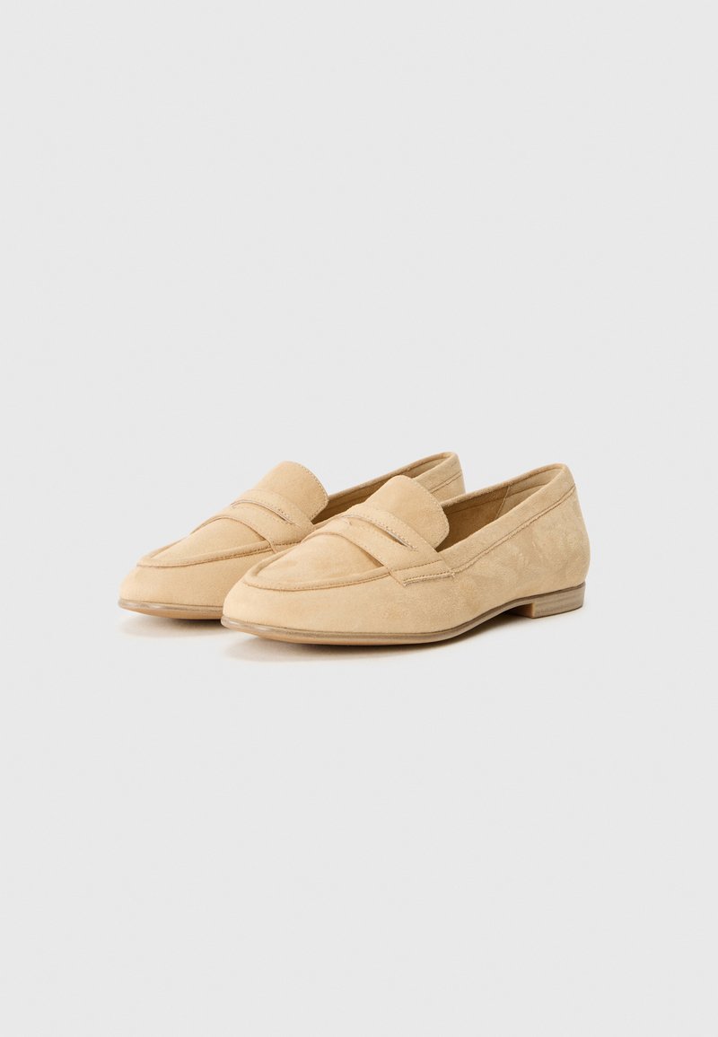 Beige Wildleder-Loafers mit einer abgerundeten Spitze, zwei dekorativen Riemen über der Vorderseite, niedrigem Holzabsatz und strukturiertem Obermaterial.