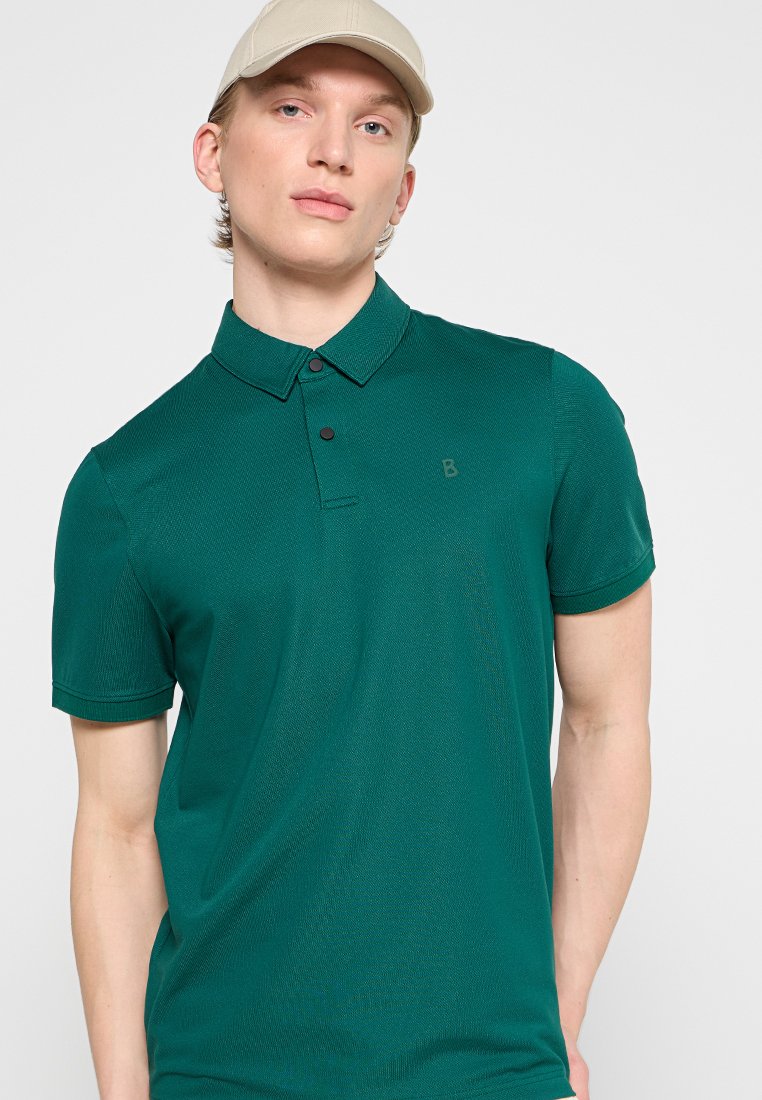 Dunkelgrünes Poloshirt mit kurzen Ärmel, aus strukturiertem Stoff, mit einem dezenten Logo auf der Brust und schwarzen Knöpfen am Kragen.