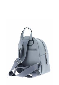 Sac à dos en cuir gris clair de forme arrondie, avec une poche zippée à l'avant et des sangles en tissu réglables. Présente une surface texturée et des accents cousus.