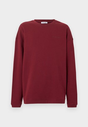 Long-sleeve burgundy sweatshirt with crew neck and subtle "Les Benjamins" text on the left chest against a white background.