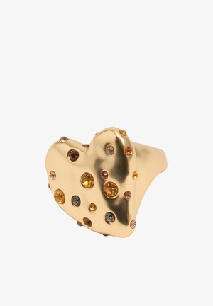 Złoty pierścionek w kształcie serca ozdobiony małymi, okrągłymi kamieniami szlachetnymi w kolorach bursztynowym, brązowym i szarym, z polerowaną i refleksyjną powierzchnią metalu.