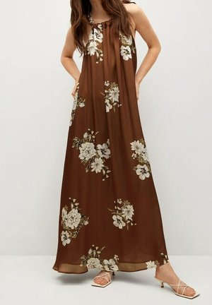 Sukienka maxi w brązowy kwiatowy wzór. Lekki, zwiewny materiał z dekoltem typu halter. Ozdobiona białymi i zielonymi kwiatami na całej powierzchni.