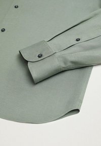 Lichtgroene button-up shirt met een gladde textuur, voorzien van een ronde zoom, verstelbare manchetten en zwarte knopen voor sluiting.