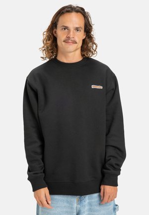 Schwarzer Sweatshirt aus Baumwolle, mit rundem Ausschnitt und gerippten Bündchen. Ein kleines Logopatch ist auf der Vorderseite sichtbar.