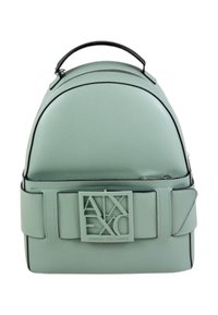 Zaino in finta pelle verde con forma arrotondata, dettagli neri, una grande placca con logo sul davanti e una maniglia superiore per il trasporto.