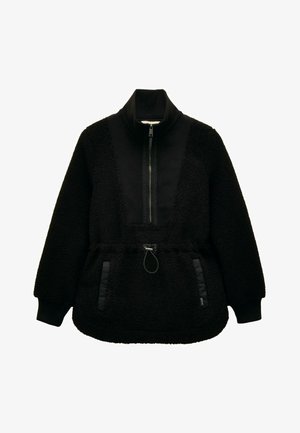 Melnā vilnas džemperis ar pusi rāvējslēdzēju priekšā, augstu apkakli, elastīgām aprocēm, savelkamu jostasvietu un divām vertikālām sānu kabatām ar neilona apdari.