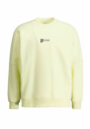 Lichtgele crewneck-sweatshirt met lange mouwen en een klein zwart "Chasin'"-logo centraal op de borst.