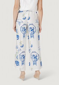 Pantaloni a gamba larga in tessuto leggero, con base bianca decorata da motivi floreali blu e accenti verdi. Vita elasticizzata per il comfort.
