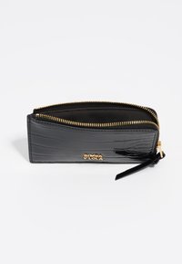 Cartera de charol negra con textura de cocodrilo, cierre de cremallera dorado y acento de marca. Forma compacta y rectangular con un detalle de borlas.