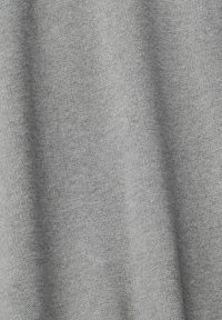 Tissu tricoté gris clair avec une texture fine et lisse et de légers plis verticaux.