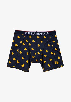 Tumši zili bokseršorti ar elastīgu jostu, kurā ir uzraksts "FUNDAMENTALS". Visā virsmā atkārtojas dzeltenu gumijas pīļu raksti.