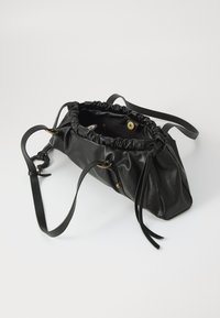 Schwarze Lederhandtasche mit gereinigtem Oberteil, verstellbaren Trägern und goldfarbener Hardware. Verfügt über eine glatte Textur und eine trapezförmige Form.
