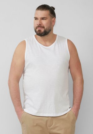 Witte mouwloze tanktop met een ronde hals, gemaakt van een lichtgewicht stof, gecombineerd met beige broek met een relaxte pasvorm.