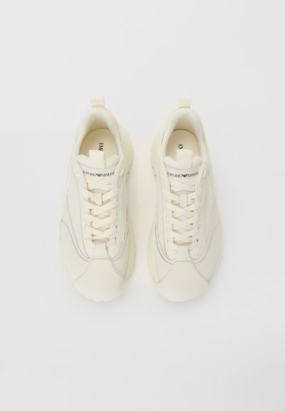 Kaks off-white Emporio Armani spordijalatsit paeltes, võrkkangast ja nahast detailidega, nähtavad ülalt lihtsa valge tausta ees.