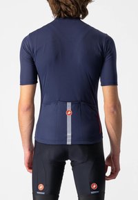 Navy Radtrikot mit kurzen Ärmeln, Rückentaschen, reflektierendem Streifen und roten Logodetails auf der Rückseite, kombiniert mit schwarzen Radshorts.