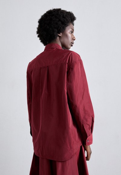 Burgundy long-sleeve shirt with a standard collar, back yoke, button cuffs, and a smooth, lightweight fabric texture.