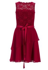 Robe en dentelle rouge avec un corsage ajusté, un décolleté festonné et une jupe en mousseline superposée. Comprend une ceinture en satin nouée à la taille.