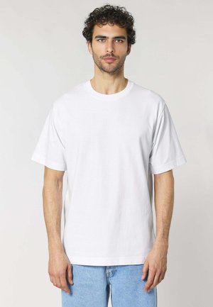 Witte katoenen t-shirt met een ronde hals en korte mouwen, met een relaxed fit en een zachte textuur, gedragen met lichtblauwe denim jeans.