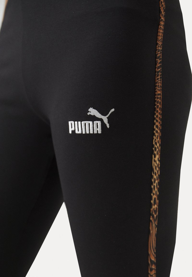 Leggings negros con un diseño ajustado, que presentan una franja de estampado de leopardo a lo largo del costado y un logo blanco de Puma en la cadera.
