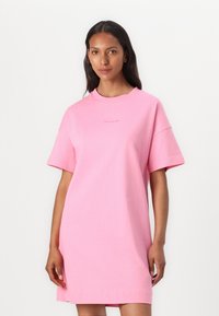 Roze oversized t-shirt jurk van zacht katoen, met een ronde halslijn en korte mouwen. Minimalistisch ontwerp met logodetail op de borst.