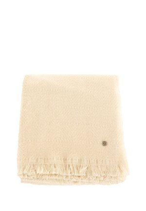 Coperta a trama intrecciata di colore crema con un motivo a diamante testurizzato, rifinita con bordi frangiati e un piccolo logo metallico.