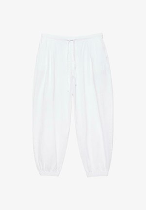 Białe, luźne spodnie z elastycznym pasem, sznurkiem do regulacji, bocznymi kieszeniami oraz elastycznymi mankietami przy kostkach, przedstawione na jednolitym tle.