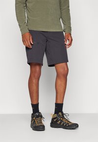 Mænds mørke grå shorts med en afslappet pasform, lavet af letvægtsstof, har lommer og er parret med sorte og orange vandrestøvler.