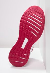 Sole di scarpa atletica rossa e bianca con un motivo testurizzato, caratterizzata da lugs rettangolari e un intaglio centrale per la flessibilità.