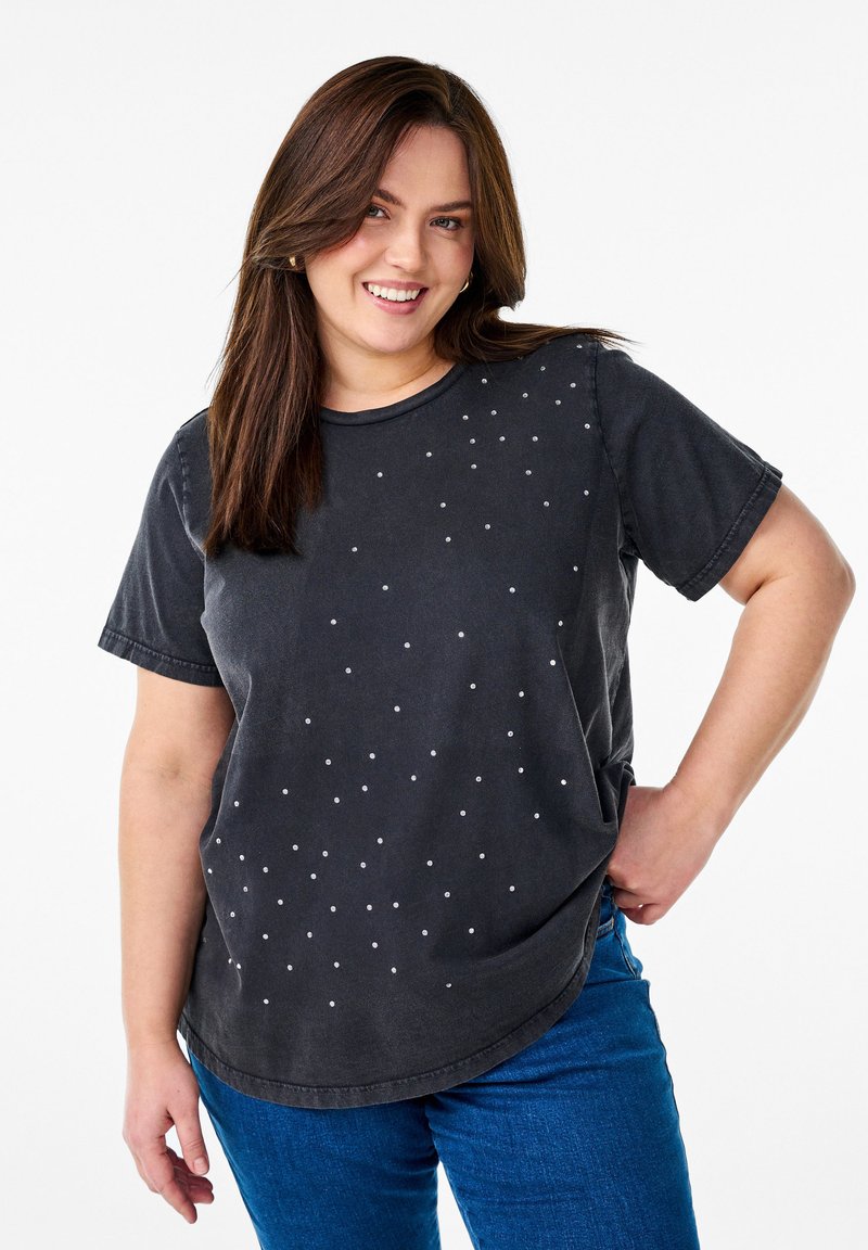 Grijze T-shirt met korte mouwen en een afgeronde zoom, versierd met verspreide witte stippen. Zacht materiaal met een ontspannen pasvorm.