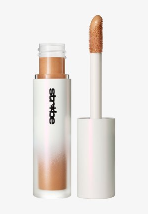 Concealer-tube med frostet hvid låg, lys beige flydende concealer indeni og applikatorstav med spids dunet tip dækket af concealer.