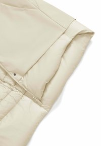 Beige pufferjack met gladde, synthetische stof, hoge kraag, ritssluiting en gequilte voering voor isolatie.
