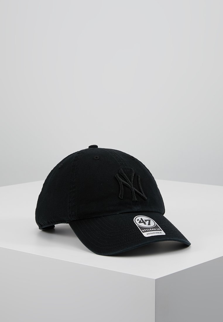 Gorra de béisbol negra hecha de algodón, con un logo bordado, visera curva y correa ajustable. Etiqueta visible en la parte delantera.