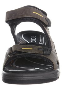 Sandalo marrone con cinturini regolabili, superficie testurizzata, soletta imbottita e suola in gomma con un design bianco e nero.