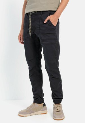 Zwarte joggerbroeken met elastische boorden, een drawstring tailleband en zijzakken. Gemaakt van een katoenen blend stof met een soepele textuur.