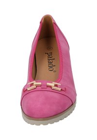 Ballerine in suede rosa con punta arrotondata, dettagli in hardware dorato e suola chiara a contrasto. L'interno presenta un'imbottitura per il comfort.