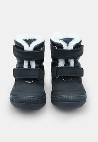 Juodi žieminiai batai su balta dirbtinės odos apdaila, dviem reguliuojamais Velcro strapais ir guminiais padais, parodyti iš priekio ant baltos fono.