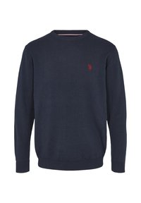 Marinblå stickad tröja med rund halsringning och ribbade ärmslut. Har en liten röd logotyp på vänster bröst. Mjuk, slät textur.